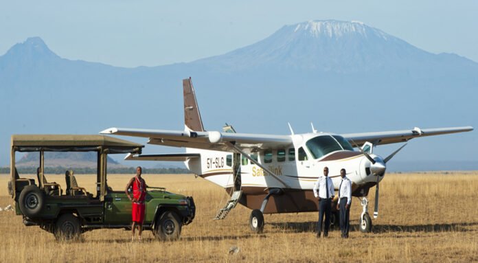 A plane lands in Amboseli airstrip and a cruiser waiting to pick up guests.