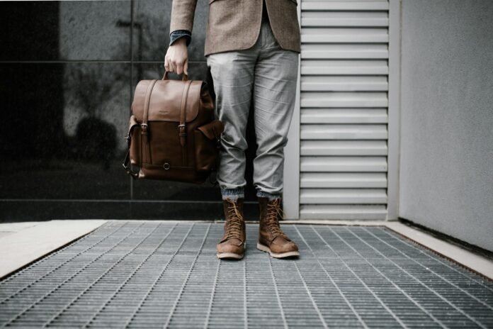 A man preparing to travel with boots on