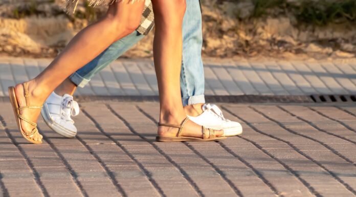 Best Sandals for Walking in Europe a ma with a woman walking with sandals in Europe